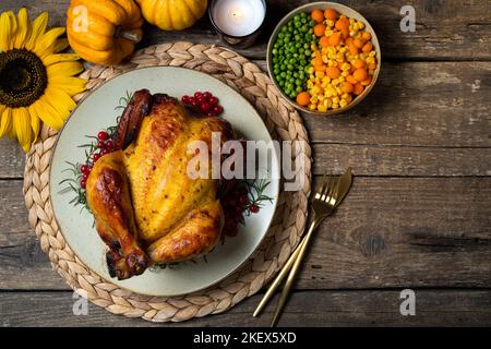 Felice giorno del Ringraziamento. Pollo intero arrosto o tacchino con verdure autunnali per la cena del Ringraziamento su tavolo di legno. Spazio di copia Foto Stock