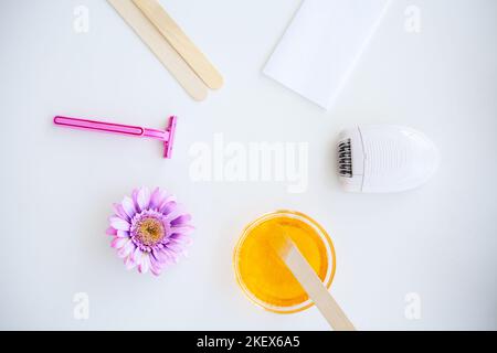 Ceratura. Impostare per l'epilazione di mezzi diversi per l'epilazione su uno sfondo bianco. Rimozione dei peli indesiderati. Epilatore moderno, strisce di cera, rasoio Foto Stock