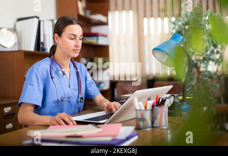 Ritratto di una giovane terapeuta che lavora in ufficio al computer Foto Stock