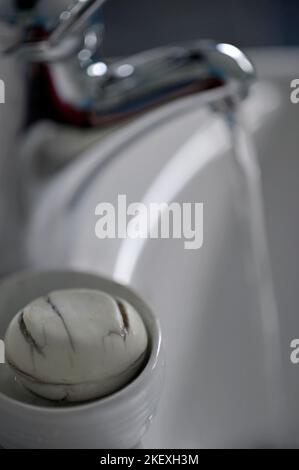 sapone piatto e acqua corrente di rubinetto nel lavabo Foto Stock