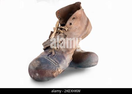 Primo piano di vecchi stivali da calcio con sfondo bianco Foto Stock