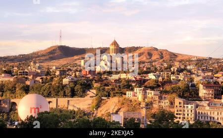 Tbilisi, Georgia - 07 23 2022: Tramonto estivo vista della città di Tbilisi Triflis la capitale della Georgia con la Cattedrale della Santissima Trinità sulla collina Foto Stock