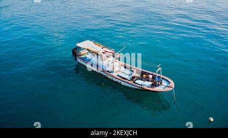 Imbarcazione da pesca ancorata dietro la barriera corallina Foto Stock