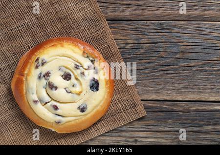 BUN con uvetta e ricotta ripieno di formaggio su vecchio tavolo di legno, vista dall'alto con spazio copia Foto Stock