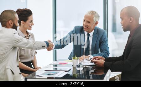 Lo dà il benvenuto al team, due uomini d'affari che si scuotono le mani durante una riunione nella sala riunioni. Foto Stock