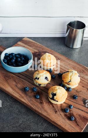 Muffin ai mirtilli sul tavolo in legno appena sfornati con mirtilli freschi Foto Stock