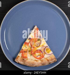 Un pezzo di pizza fatta in casa sul piatto. Vista dall'alto Foto Stock