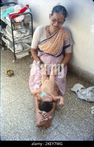 Bambino neonato massaggiato con olio, Bombay, India Foto Stock