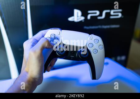 Bangkok, Thailandia - 30 ottobre 2022: Giocatore che gioca alla console di gioco PlayStation 5 con il controller DualSense. Foto Stock