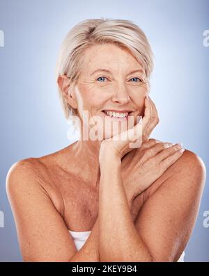 Bellezza, cura della pelle e ritratto di donna matura con sorriso sul volto su sfondo blu. Salute, benessere e pensione, donna anziana felice con cura della pelle Foto Stock