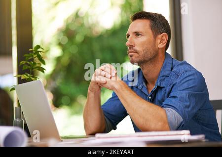 Sentirsi sicuri della sua piccola impresa. Un uomo che guarda premuroso mentre lavora da casa. Foto Stock