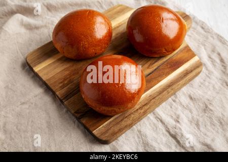 Hamburger Buns Brioche fatti in casa su una tavola di legno, vista laterale. Foto Stock