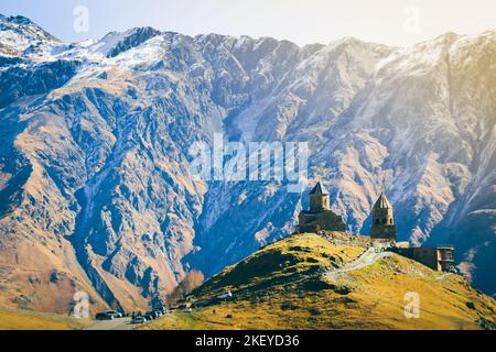 Stepantsminda, Georgia. Famosa popolare chiesa di Gergeti Trinity Tsminda Sameba nel paesaggio dell'inizio dell'inverno. Splendido paesaggio delle montagne georgiane Foto Stock