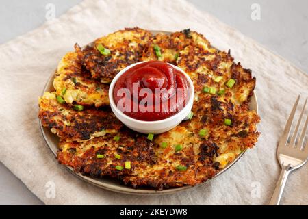 Cavolfiore casereccio Cheddar Fritters con erba cipollina su un piatto, vista laterale. Foto Stock