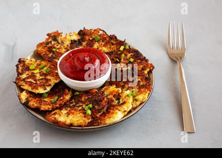 Cavolfiore casereccio Cheddar Fritters con erba cipollina su un piatto, vista laterale. Foto Stock