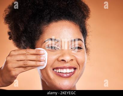 Viso, pelle e donna nera con imbottitura in cotone su sfondo arancione studio mockup. Modello felice, salutare e femminile con prodotto per la pulizia del viso Foto Stock