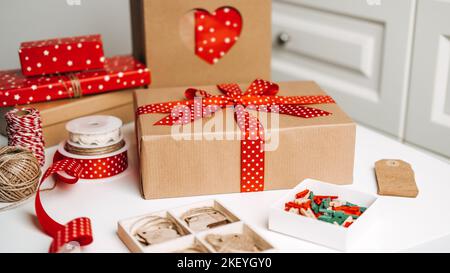 Natale idee regalo banner web. Rosso marrone Natale scatola regalo, borsa di carta kraft shopping e nastri per la confezione. Eco-friendly sostenibile zero sprechi Foto Stock