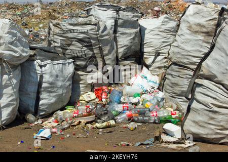 foto di scorta dei sacchetti di raccolta rifiuti e delle bottiglie di plastica vuote nel sito di smaltimento rifiuti pronti per essere raccolti dalla società di smaltimento rifiuti per il riciclaggio Foto Stock