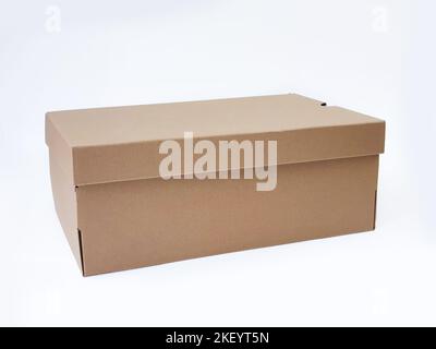 Scatola marrone in cartone per scarpe con coperchio per scarpe o sneaker, isolata su fondo bianco con percorso di ritaglio. Scatola di carta del mestiere. Avanti Foto Stock