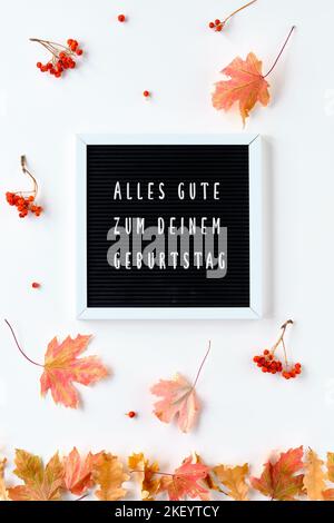 Alles Gute zum deinen Geburtstag testo significa tutto il meglio sul vostro compleanno in tedesco. Foglie autunnali, bacca di rowan e saluto sulla lavagna di testo. Felice Foto Stock