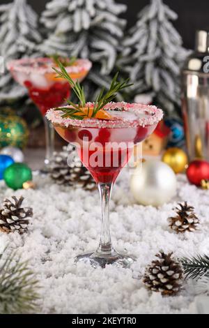 Il cocktail Christmas Cranberry margarita è un mandarino e rosmarino combinato con mirtilli e tequila. Questo cocktail è ricco di vivaci agrumi Foto Stock