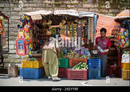 Donna cliente che acquista qualcosa in un negozio di strada sul ciglio di una città in India Foto Stock