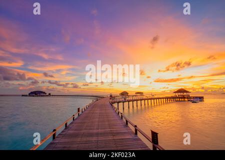 Incredibile panorama al tramonto alle Maldive. Ville resort di lusso con luci soffuse a LED sotto il cielo colorato. Bel cielo crepuscolo e nuvole colorate Foto Stock