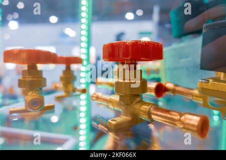 Valvole a sfera, valvole di arresto, azionate manualmente per invertire il flusso del refrigerante. Foto Stock