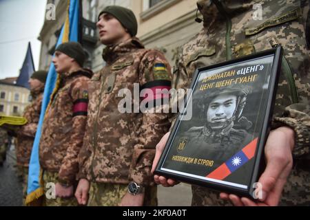 Un soldato tiene un ritratto di Tseng Sheng-Guang, ucciso dalle truppe russe in Ucraina durante la cerimonia di congedo. Tseng Sheng-Guang (12.09.1997-02.11.2022) è un nativo di Taiwan. Si è laureato alla Scuola superiore Szu Wei di Hualien City. Durante il 2017-2021, prestò servizio nelle forze armate della Repubblica di Cina. Ricevuto il grado militare di 'Corporal'. Con l'inizio dell'invasione su vasta scala della Federazione Russa sul territorio dell'Ucraina, si unì volontariamente alle file delle forze armate ucraine. Combatté contro gli invasori russi come parte del fucile separato del 49th Foto Stock