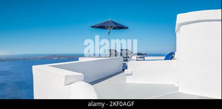 Incredibile destinazione panoramica. Due sedie ombrellone sulla terrazza caldera a Santorini, Grecia. Architettura famosa e bianca, vista sul cielo blu del mare. Luna di miele Foto Stock