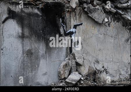 Borodyanka, Ucraina. 14th Nov 2022. Graffiti del famoso artista di strada anonimo Banksy è mostrato su uno degli edifici di appartamenti distrutti dall'esercito russo nella città di Borodyanka, a nord-ovest della capitale Ucraina Kyiv. Banksy pubblicò una foto graffiti di un ginnasta che faceva un cavalletto sul suo Instagram. Sul suo Instagram, pubblica solo il suo lavoro. (Foto di Sergei Chuzavkov/SOPA Images/Sipa USA) Credit: Sipa USA/Alamy Live News Foto Stock