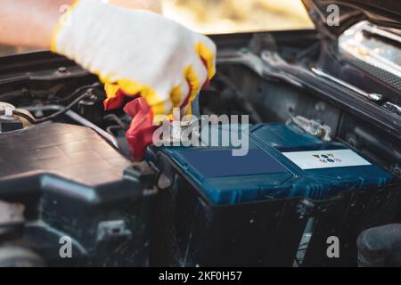 Riparazione e sostituzione della batteria dell'auto. Il meccanico sta effettuando la manutenzione della vettura. Foto Stock