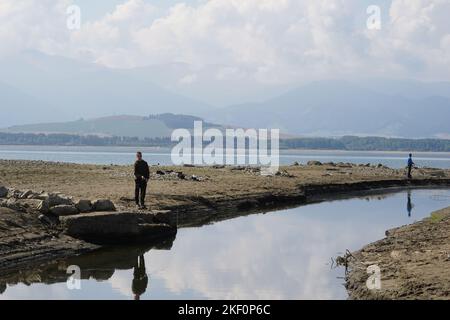 Due pescatori che pescano in arido o essiccato su piccolo canale fluviale che fornisce acqua per diga Liptovska Mara. Foto Stock