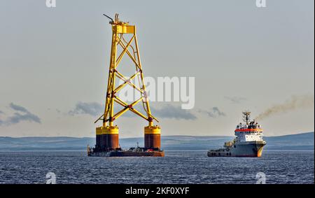 Cromarty Firth Scotland Nigg nave che traina la base gialla di una turbina eolica offshore nel porto Foto Stock