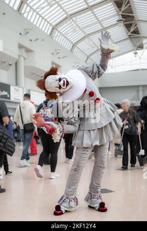 Un cosplayer maschile vestito come Pennywise The Clown dalla serie IT di libri e film di Stephen King al MCM Birmingham Comic con 2022 Foto Stock