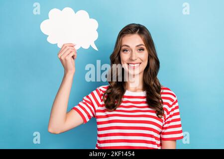 Foto di adorabile bella ragazza vestita t-shirt rossa tenendo bianco carta nuvola vuoto spazio isolato di colore blu sfondo Foto Stock