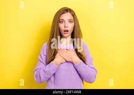 Foto di giovane ragazza scioccata paurita adolescente indossare confortevole maglione viola toccare petto reazione infelice isolato su sfondo di colore giallo Foto Stock