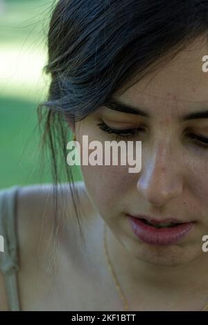 Primo piano ritratto donna business. . – giovane donna che guarda giù in concentrazione ispanica Foto Stock