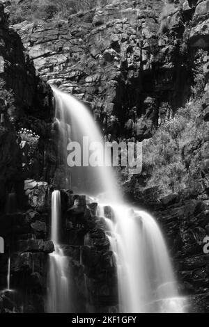 Immagine in scala di grigi con esposizione alla luce verticale di un waterfa Foto Stock