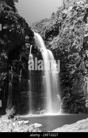 Immagine verticale in scala di grigi con esposizione alla luce di una cascata Foto Stock