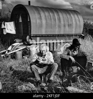 Uomini Rom che mangiano cena al tramonto nel Worcestershire. Fotografia in bianco e nero. Foto Stock