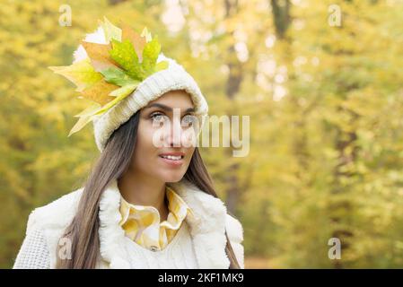 Attraente donna in posa in foresta con colorate foglie autunnali Foto Stock