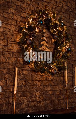 Corona di Natale su un muro di mattoni marrone. Umore di Natale Foto Stock
