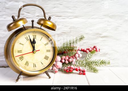 Decorativo albero di Natale e bronzo sveglia conto alla rovescia a mezzanotte su sfondo bianco di legno. Concetto di Capodanno. Banner, intestazione, biglietto d'auguri, poll Foto Stock
