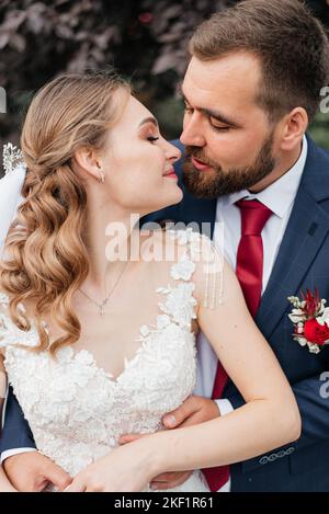 Sposa e lo sposo in un parco kissing.giovane sposi sposa e lo sposo a un matrimonio in natura verde della foresta sono kissing foto ritratto.coppie in viaggio di nozze Foto Stock