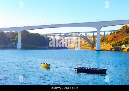 Ponti ferroviari di Dona Maria Pia e Sao Joao, barche al fiume Douro, sera, Porto, Portogallo Foto Stock