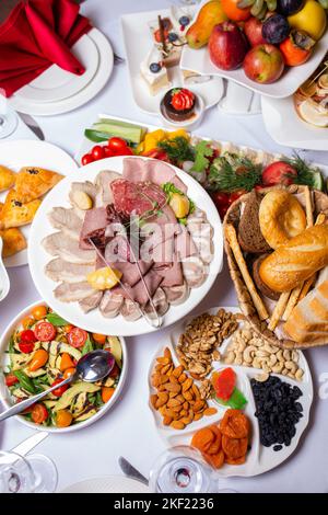 vista dall'alto di una varietà di spuntini a buffet presso l'hotel. salumi, formaggi assortiti e noci Foto Stock