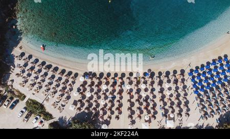 Una vista aerea della spiaggia di Sarakiniko con mare turchese e ombrelloni allineati in Grecia Foto Stock