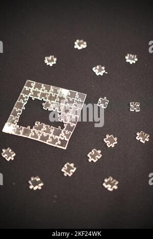 Primo piano di un puzzle con pezzi trasparenti. Foto Stock