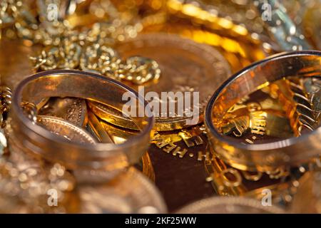 Gioielli d'oro, monete d'oro e barre d'oro in un primo piano Foto Stock